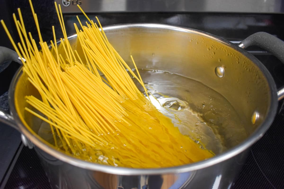 Spaghetti just added to a large pot of boiling water.