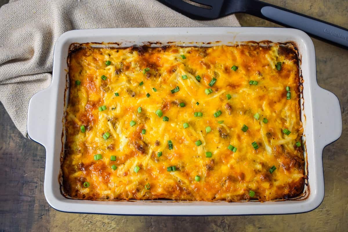 The finished sausage hash brown casserole garnished with sliced green onions.