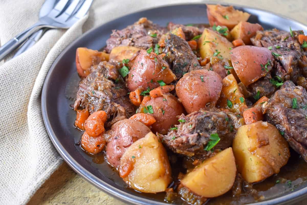 The beef and potatoes served on a large gray platter.