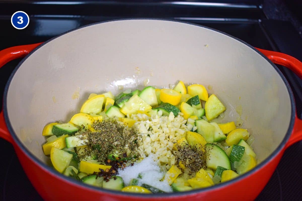 Minced garlic and spices added to the squash and onions in the pot.