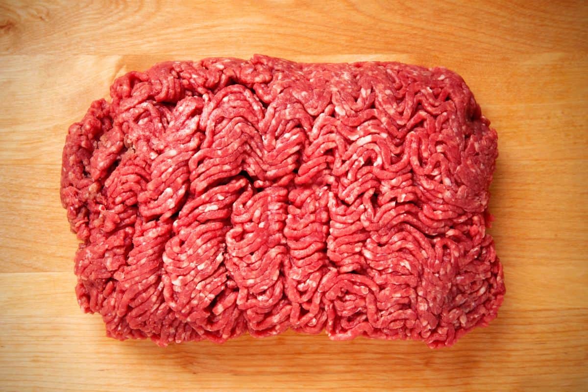 Raw ground beef on a wood cutting board.