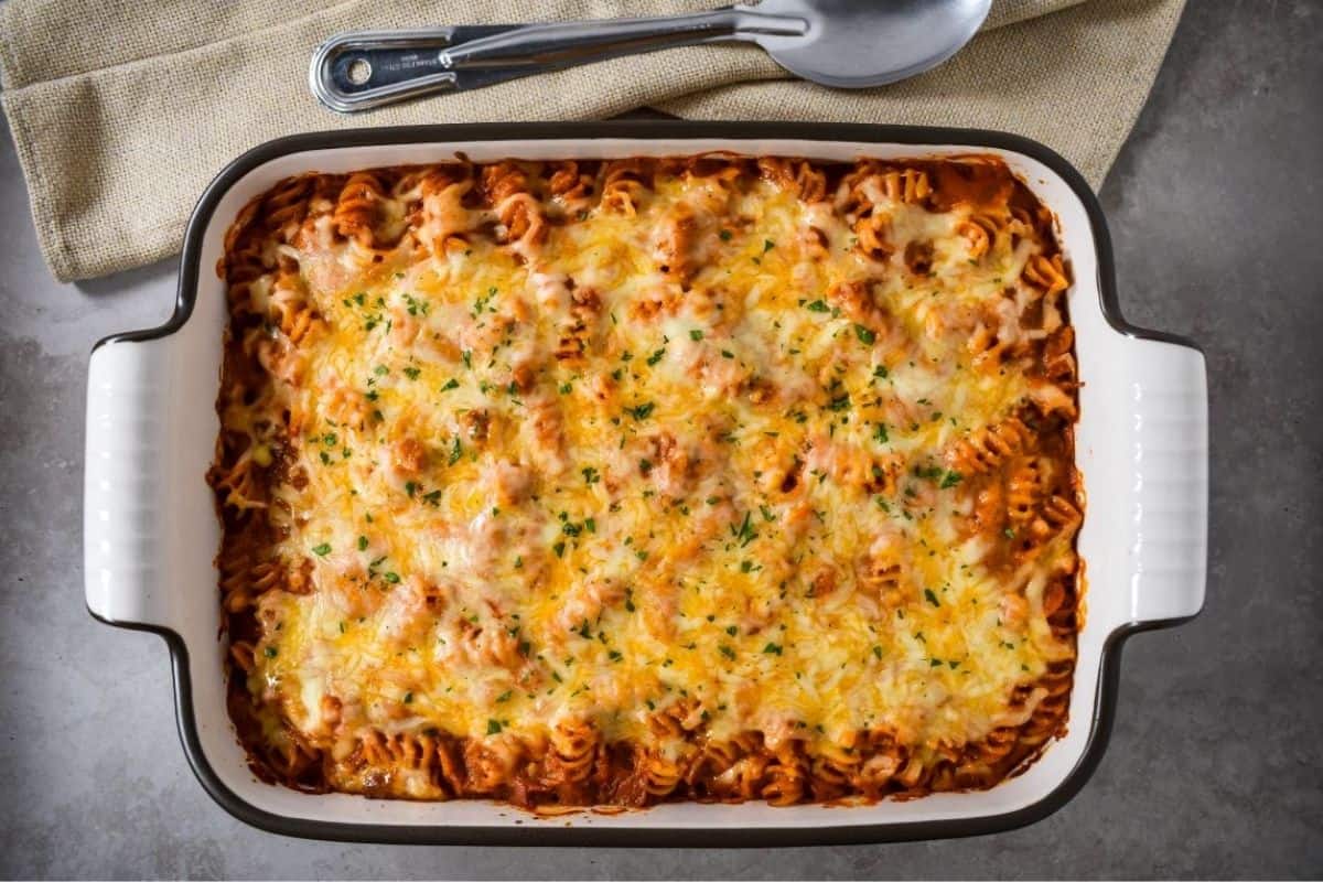 A overhead shot of the entire vodka sauce pasta bake in a casserole dish, showing the cheese topping.