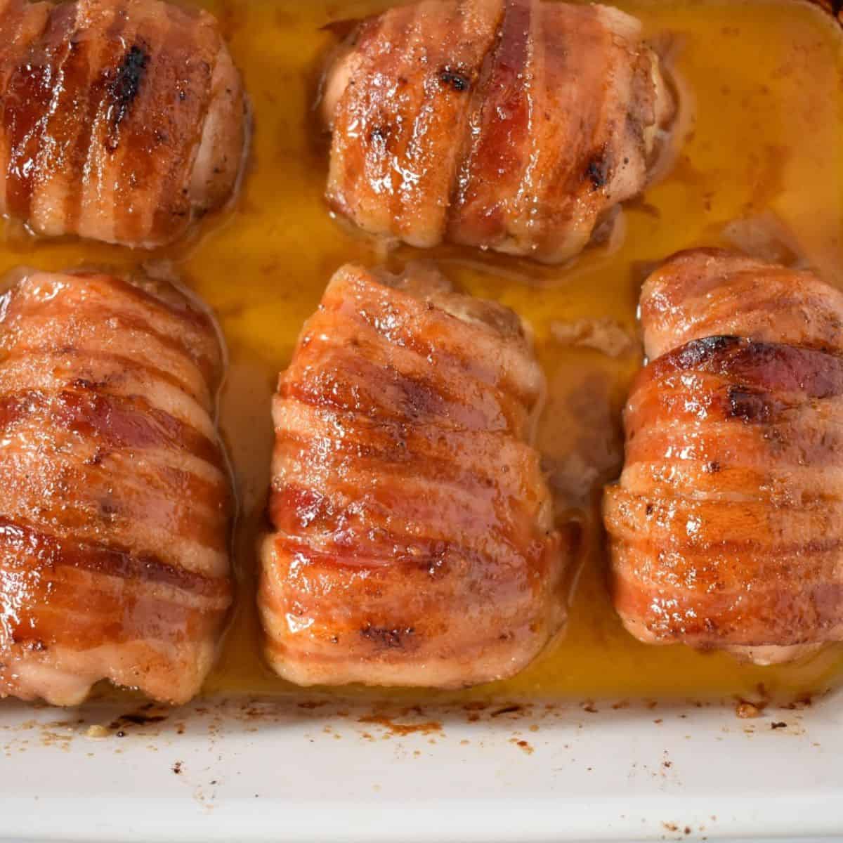 An image of the baked chicken thighs still in the white casserole dish.