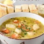 A bowl of chicken and stars soup with diced chicken, carrots, and parsley in a light broth. Served with sliced bread in the background. Text overlay reads “Chicken & Stars Soup – quick & easy recipe!”