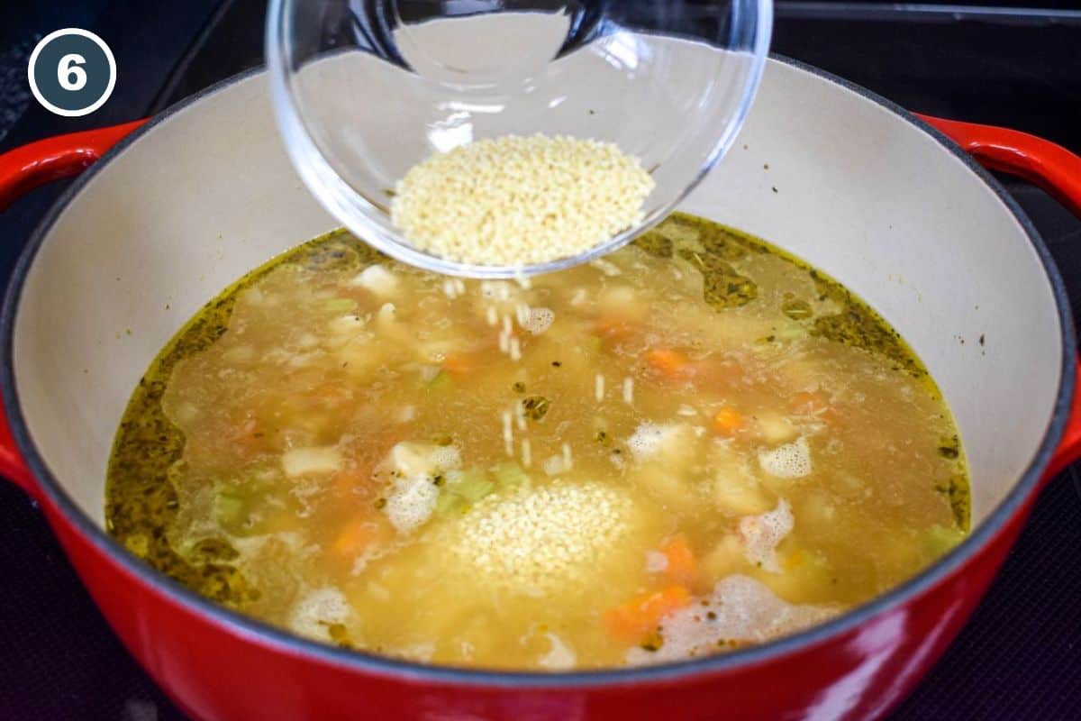 Adding stelline pasta to the simmering soup.