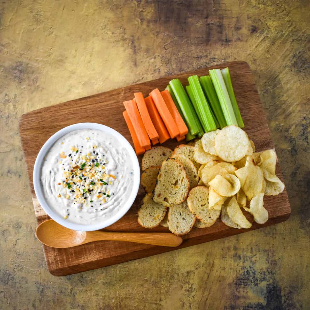 Overhead shot of the dip board with colorful vegetables and chips arranged for serving.