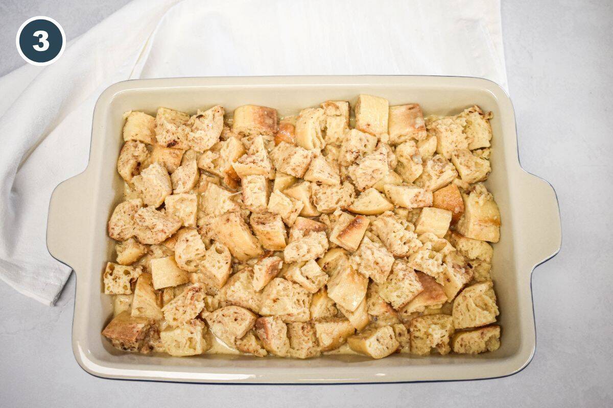Bread mixture poured into a baking dish, ready to soak up the custard.