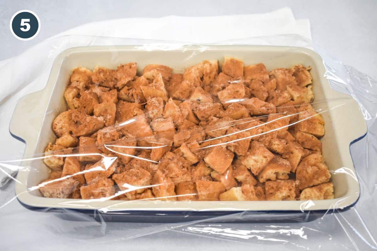 Casserole dish covered with plastic wrap, ready to refrigerate overnight.