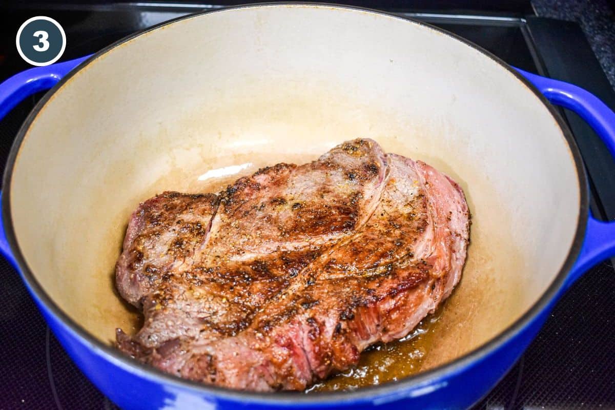 Chuck roast after browning on one side in the Dutch oven.