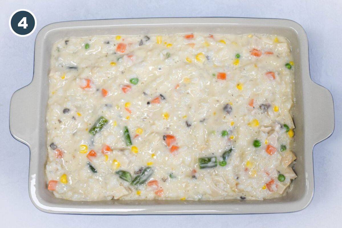 Unbaked casserole mixture spread evenly in a rectangular baking dish.