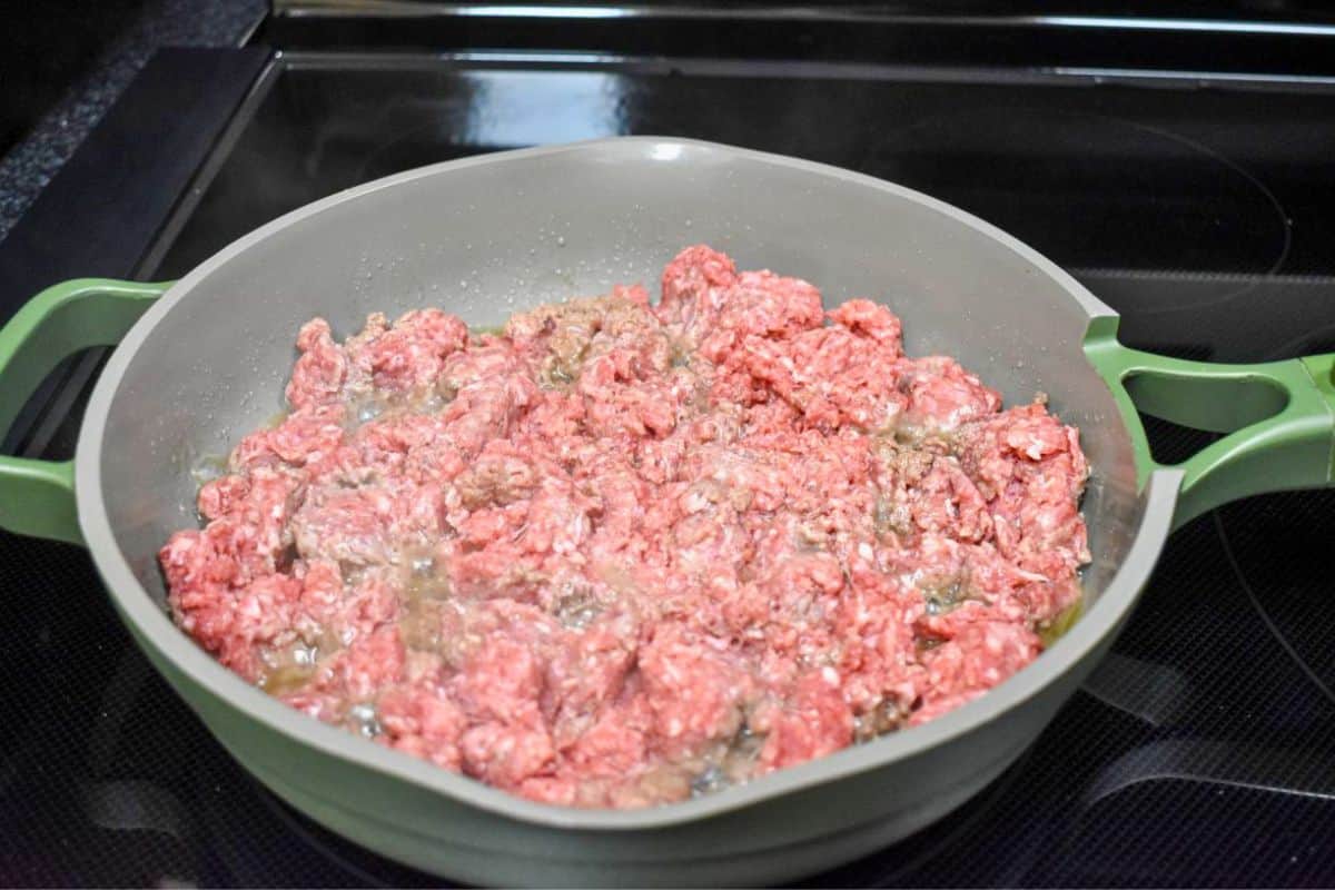 Ground beef cooking in a skillet.