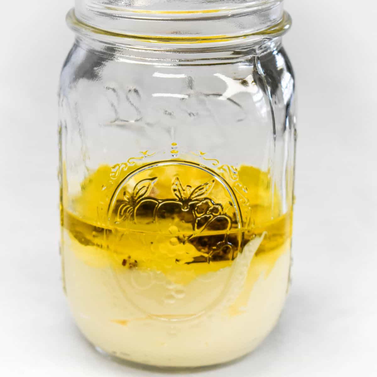 Ingredients for homemade aioli added to a mason jar before mixing.