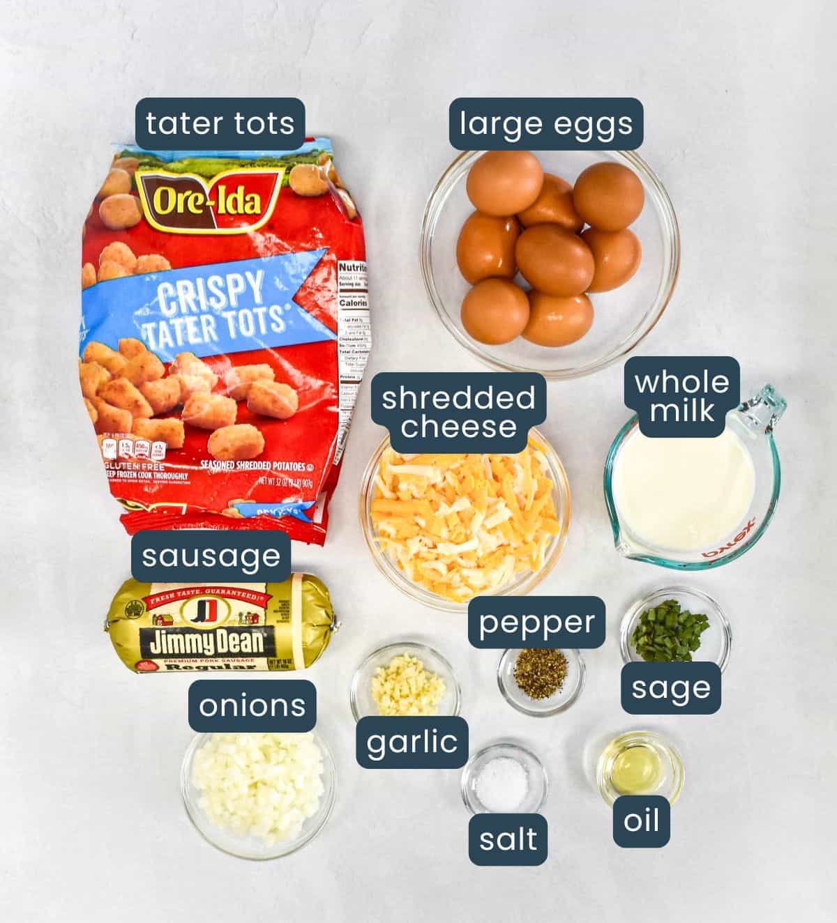 Ingredients needed to make tater tot breakfast casserole arranged on a table and labeled.