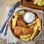 Homemade tartar sauce served with battered fish, French fries, and lemon wedges.