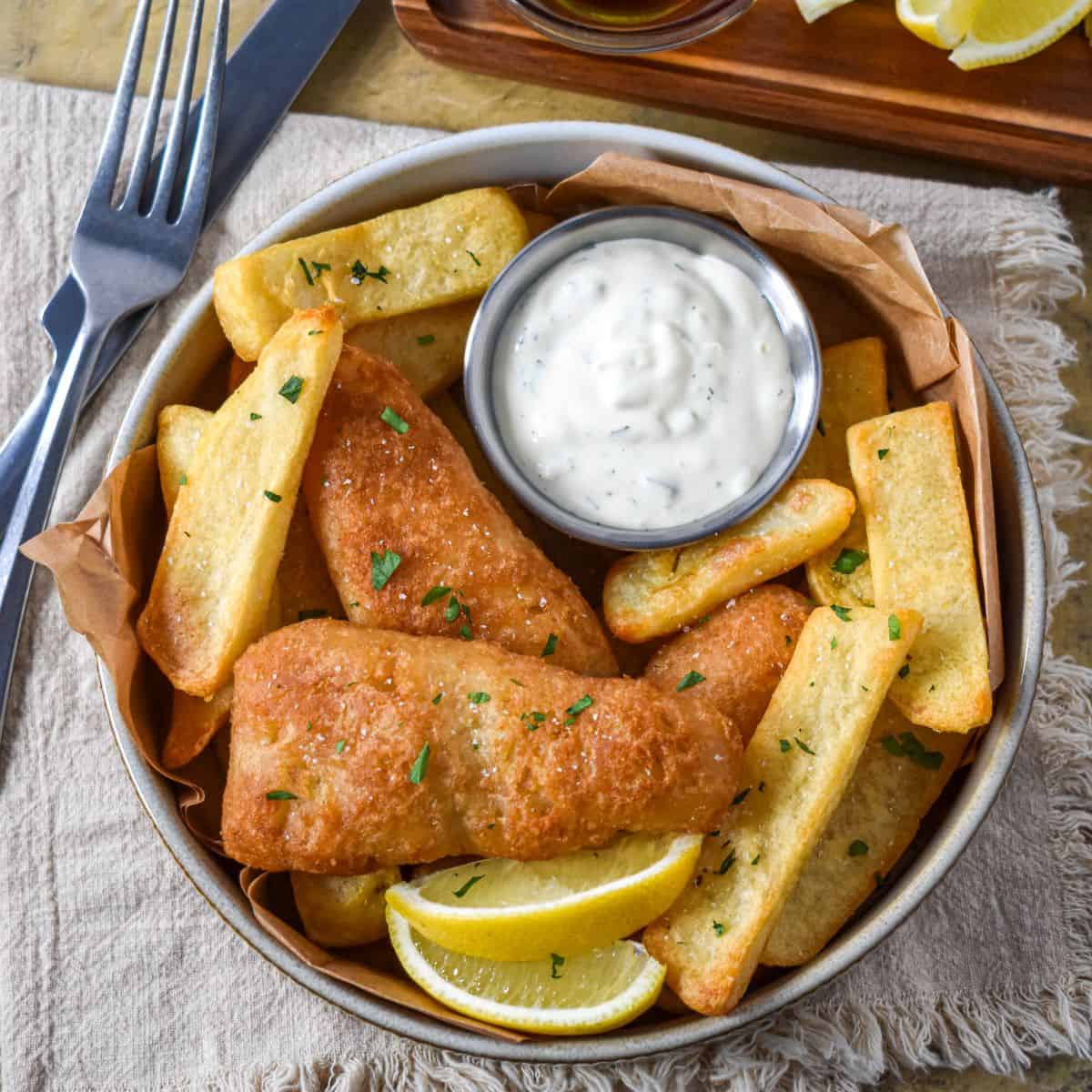 Creamy tartar sauce served with battered fish and French fries.