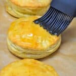 Pastelito de carne being glazed with honey with a gray pastry brush