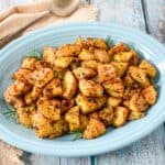 Roasted gold potatoes served on a blue platter.