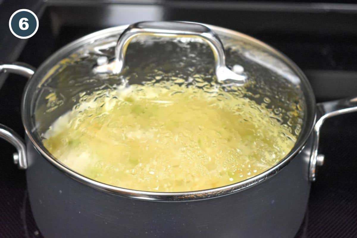 Celery soup simmering in a covered saucepan.
