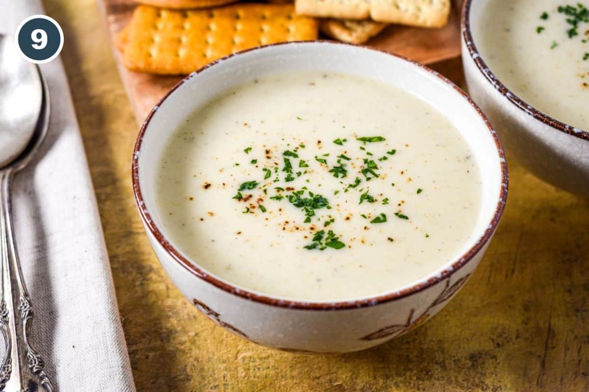 Cream of celery soup garnished with parsley and black pepper.